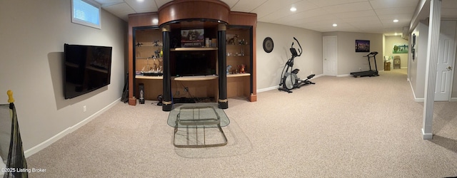 exercise room with light colored carpet and a paneled ceiling