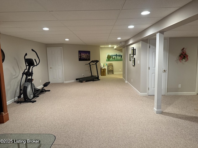 workout room with a paneled ceiling and light colored carpet