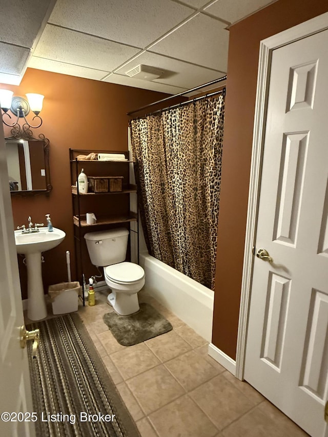 full bathroom with tile patterned floors, toilet, sink, shower / bath combo, and a drop ceiling