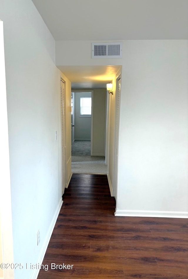 corridor with dark hardwood / wood-style flooring