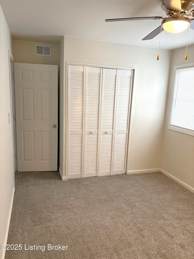 unfurnished bedroom with a closet, ceiling fan, and carpet flooring