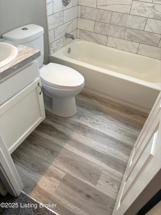 full bathroom with vanity, hardwood / wood-style flooring, shower / bathtub combination, and toilet