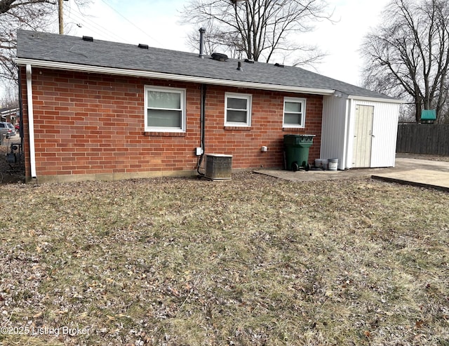 rear view of property with central AC unit, a lawn, and a patio area