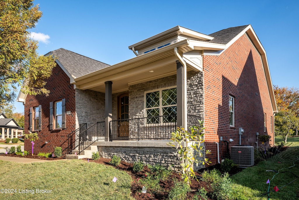 view of front facade with central AC, a front lawn, and a porch