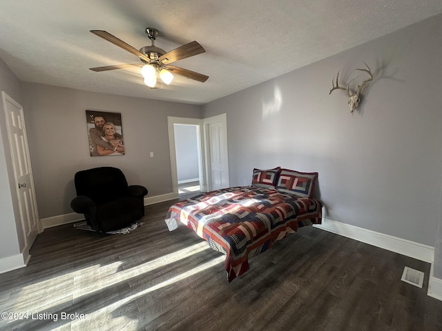 bedroom featuring a textured ceiling, dark hardwood / wood-style floors, and ceiling fan