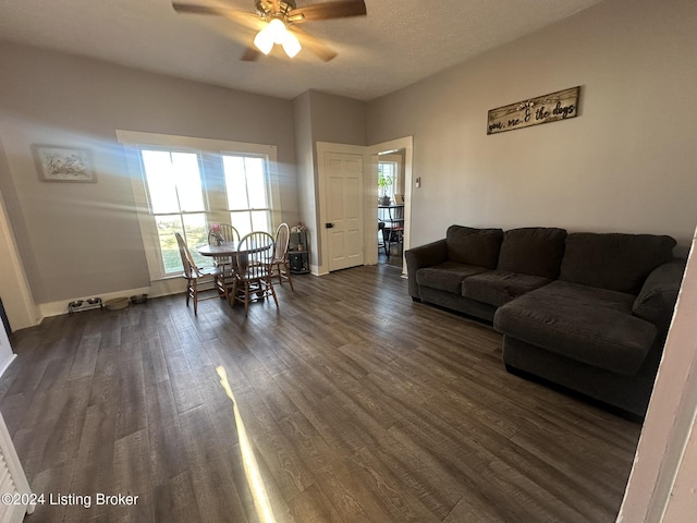 living room with ceiling fan, dark hardwood / wood-style floors, and a textured ceiling