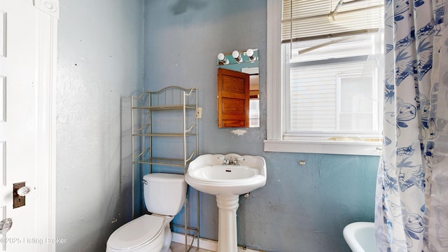 bathroom with toilet and a shower with shower curtain