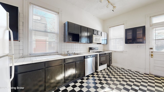 kitchen featuring white appliances, sink, and a wealth of natural light