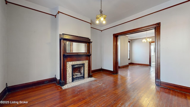 unfurnished living room with a chandelier and hardwood / wood-style floors