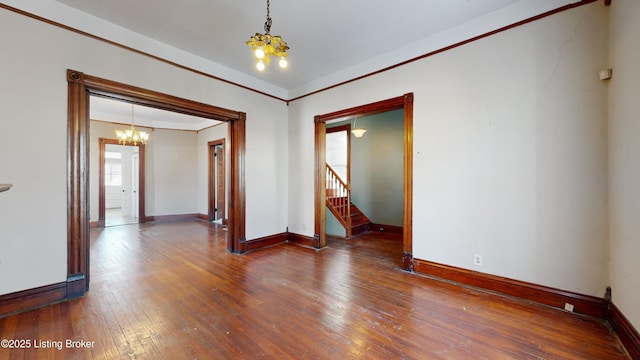 empty room with an inviting chandelier and hardwood / wood-style flooring