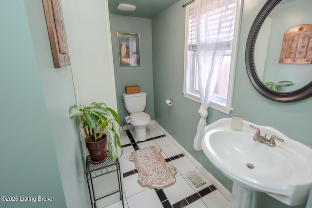 bathroom featuring toilet, tile patterned flooring, and sink