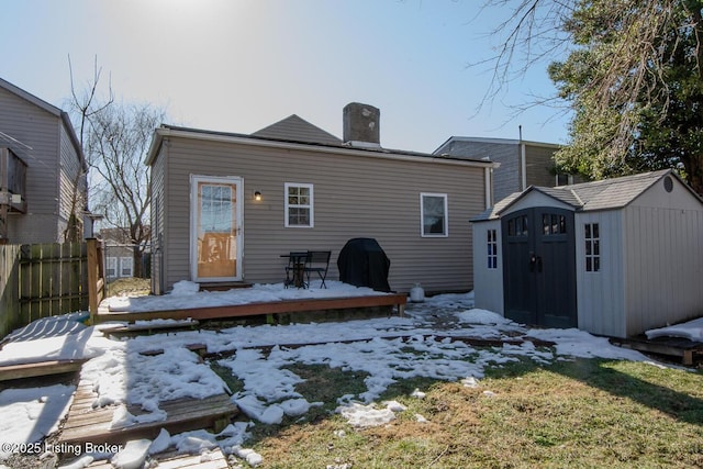 back of house featuring a deck and a storage shed