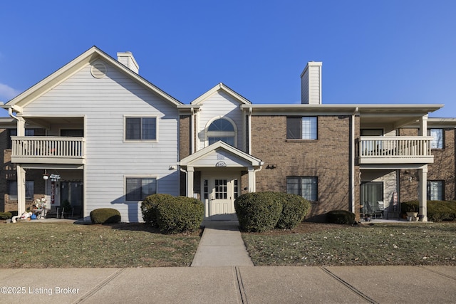 view of property featuring a front yard and a balcony