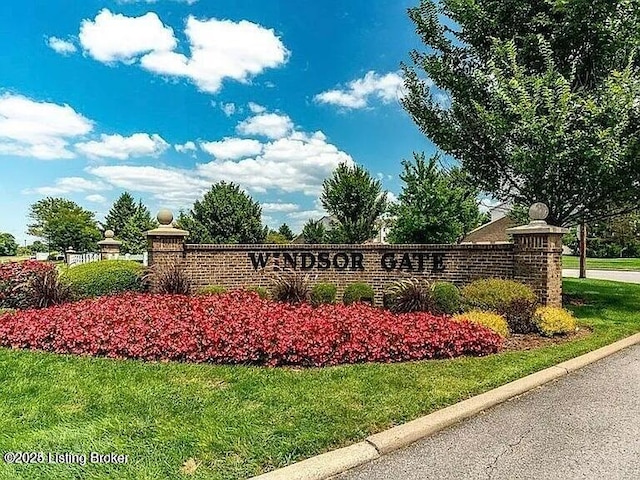 community / neighborhood sign featuring a lawn