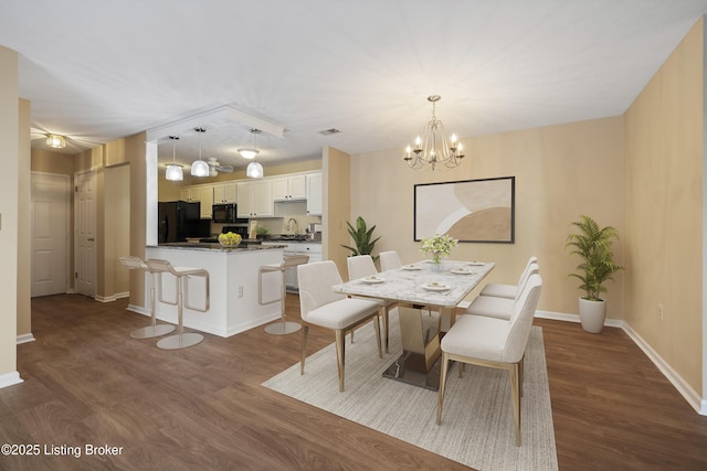 dining room featuring wood-type flooring, a chandelier, and sink