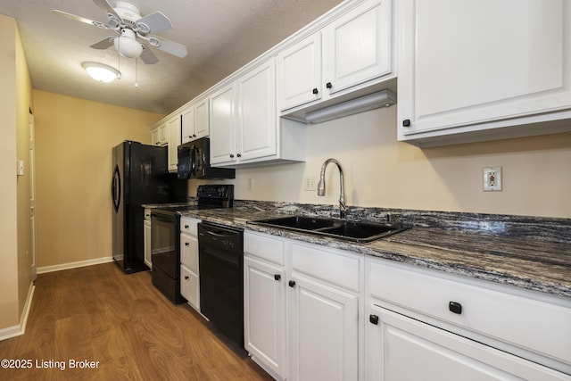 kitchen featuring sink, black appliances, and white cabinets