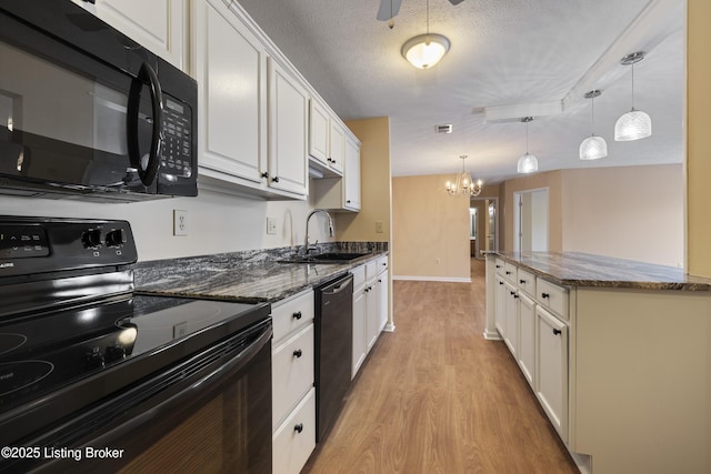 kitchen with pendant lighting, white cabinetry, sink, and black appliances