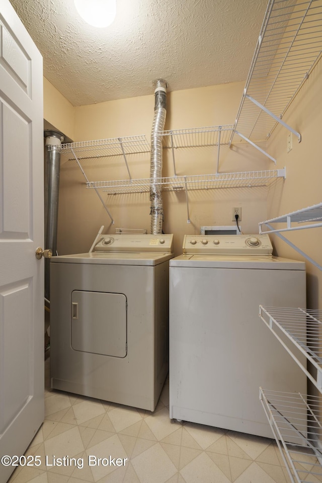 laundry area featuring washer and dryer and a textured ceiling