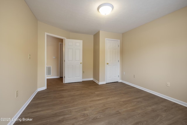 unfurnished bedroom with dark hardwood / wood-style flooring