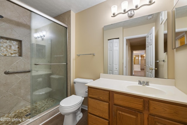 bathroom featuring walk in shower, vanity, and toilet