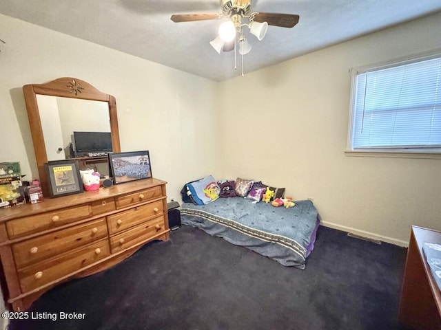 bedroom featuring ceiling fan and dark carpet