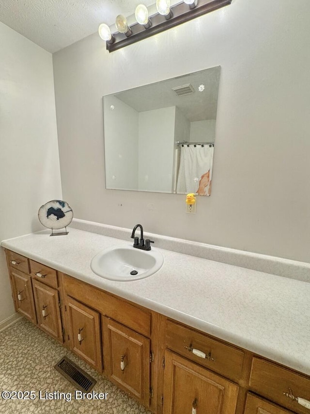 bathroom with vanity and a textured ceiling