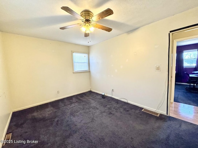 carpeted spare room featuring a textured ceiling and ceiling fan