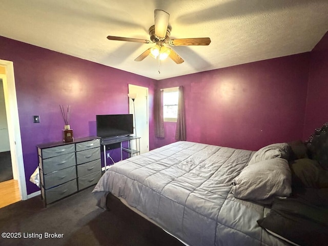 bedroom featuring ceiling fan, carpet floors, and a textured ceiling