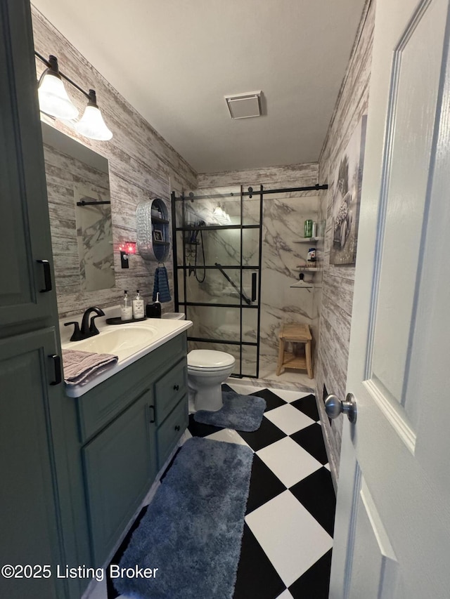 bathroom with tile walls, vanity, toilet, and walk in shower