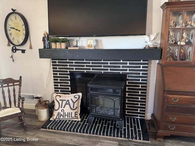 room details featuring wood-type flooring and a brick fireplace