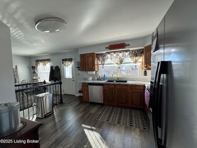 kitchen featuring dark wood-type flooring, sink, tasteful backsplash, appliances with stainless steel finishes, and a wealth of natural light