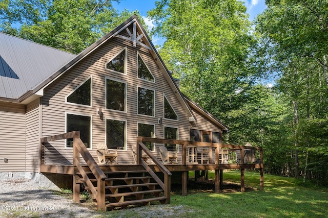 back of property with a deck and a lawn