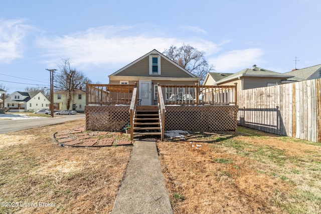 back of house with a wooden deck and a lawn