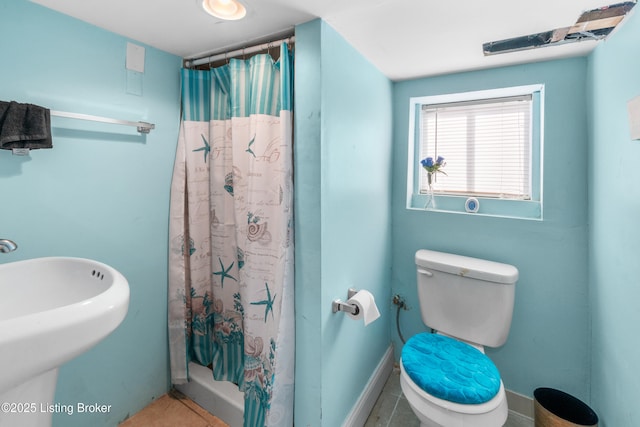 bathroom with walk in shower, sink, tile patterned floors, and toilet