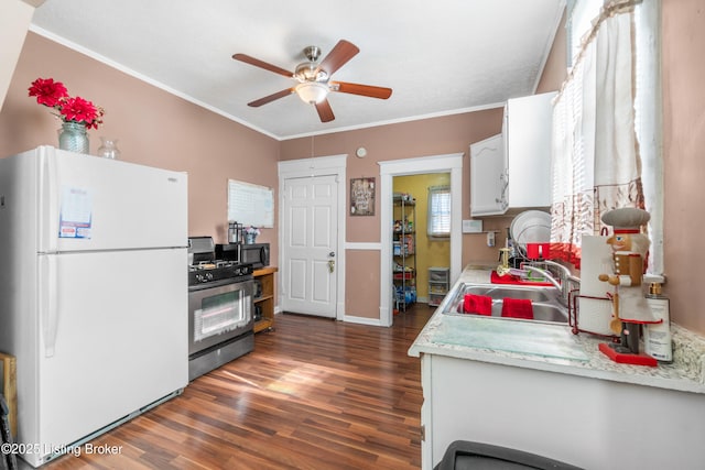 kitchen with stainless steel range with gas cooktop, sink, white cabinets, white fridge, and dark wood-type flooring