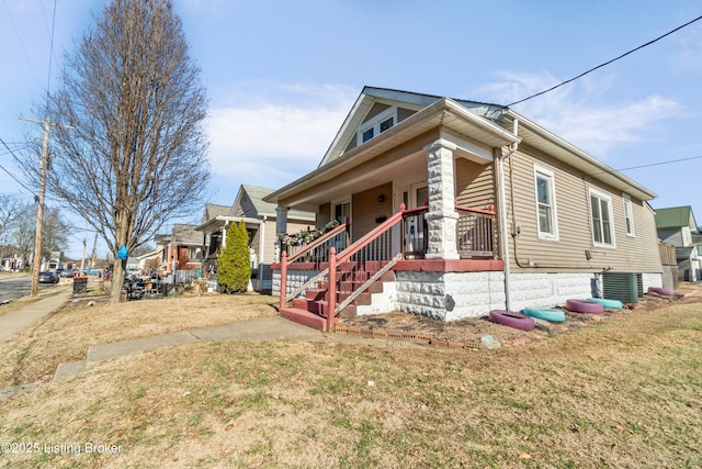 view of front of property featuring cooling unit, a front yard, and covered porch