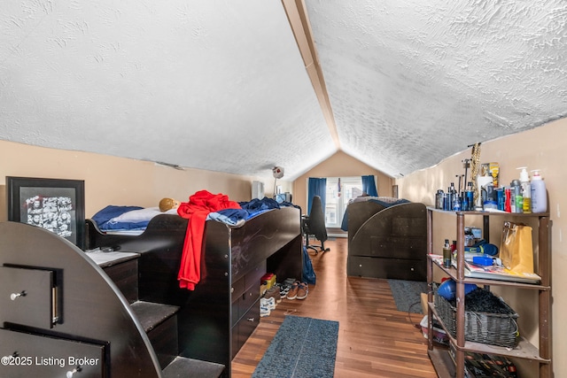 bedroom with hardwood / wood-style flooring, vaulted ceiling, and a textured ceiling