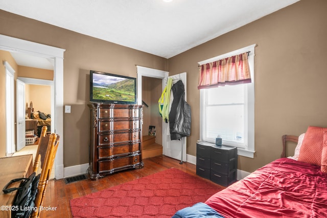 bedroom with dark hardwood / wood-style floors