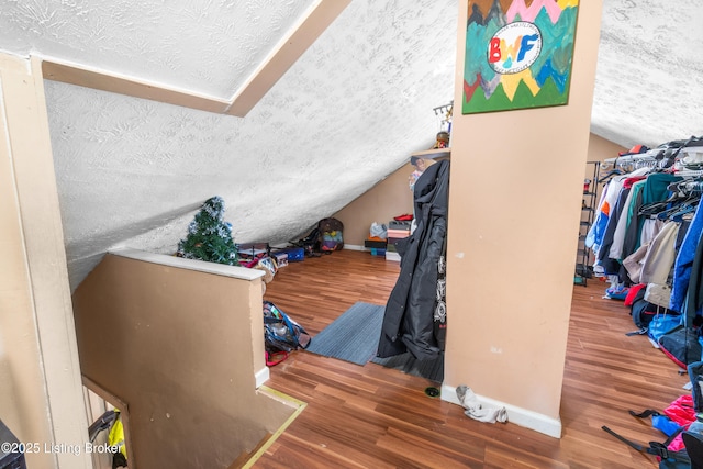 interior space with vaulted ceiling, hardwood / wood-style floors, and a textured ceiling