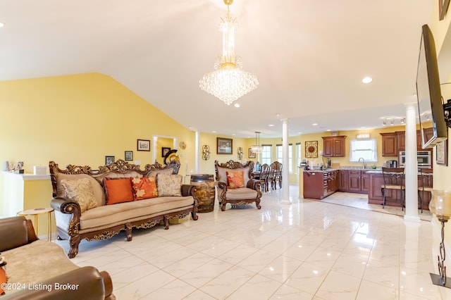 living room featuring a notable chandelier, lofted ceiling, sink, and ornate columns