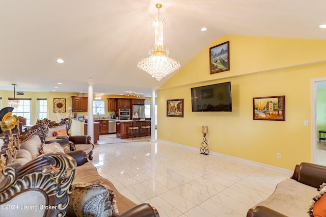 living room featuring an inviting chandelier, sink, vaulted ceiling, and ornate columns