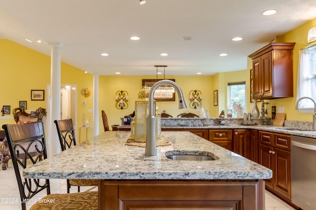 kitchen featuring sink, a breakfast bar area, ornate columns, a center island, and stainless steel dishwasher