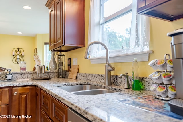 kitchen with light stone counters, sink, and plenty of natural light