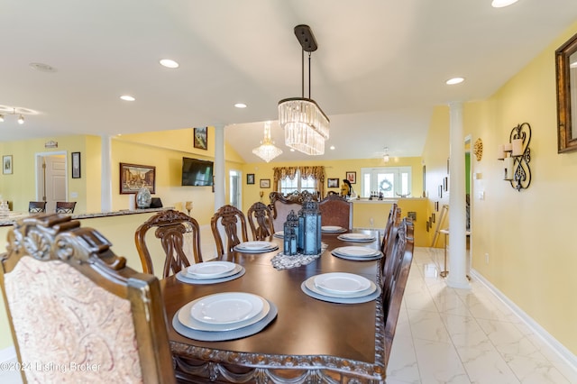 dining space with vaulted ceiling and decorative columns