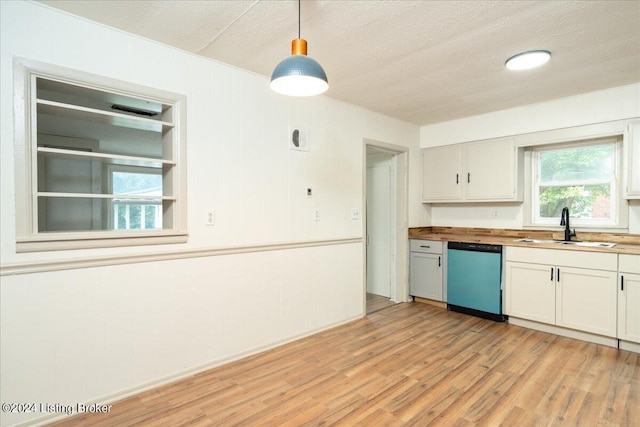 kitchen with pendant lighting, dishwasher, sink, white cabinets, and light wood-type flooring