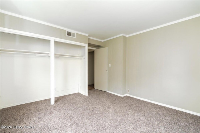 unfurnished bedroom with ornamental molding, carpet floors, and a closet