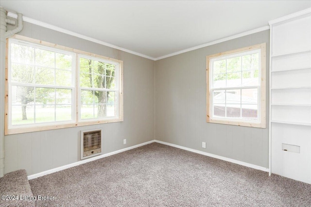 empty room featuring heating unit, carpet floors, and ornamental molding