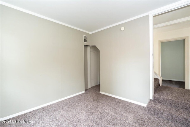 spare room featuring ornamental molding and carpet flooring