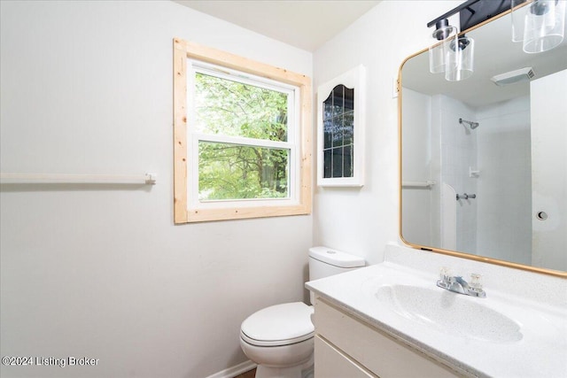 bathroom with vanity, toilet, and a shower