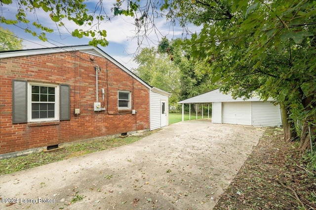 view of property exterior with a garage, a carport, and an outbuilding